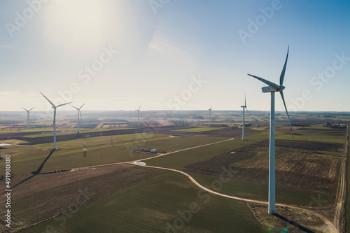 Turbiny wiatrowe, wiatraki produkują energię odnawialną z wiatru na pięknych malowniczych polach oświetlone słońcem