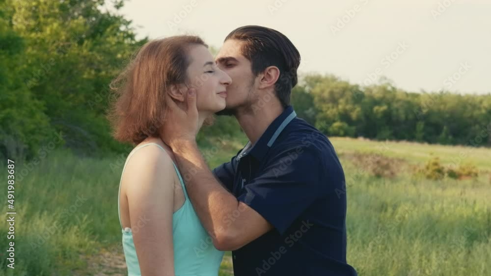 Husband kisses his wife. Young couple on date surrounded by nature. Husband kisses his wife. Young couple on date surrounded by nature.