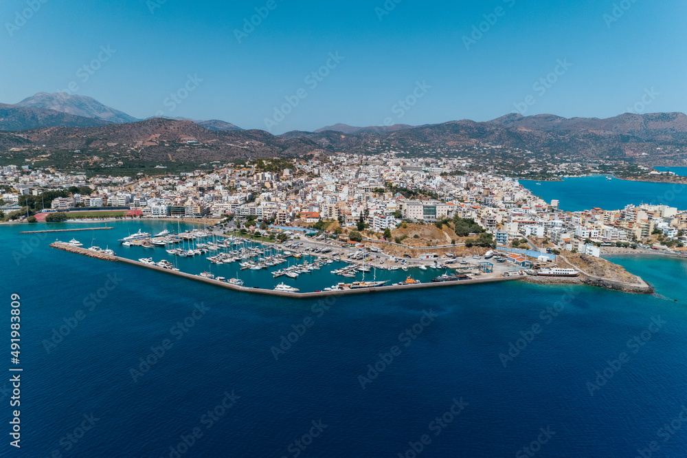 Ujęcie. z drona na piękne greckie miasto Ajos Nikolaos na wyspie Kreta w Grecji, port i marina u wybrzeży morza śródziemnego, idealna wakacyjna destynacja  - obrazy, fototapety, plakaty 