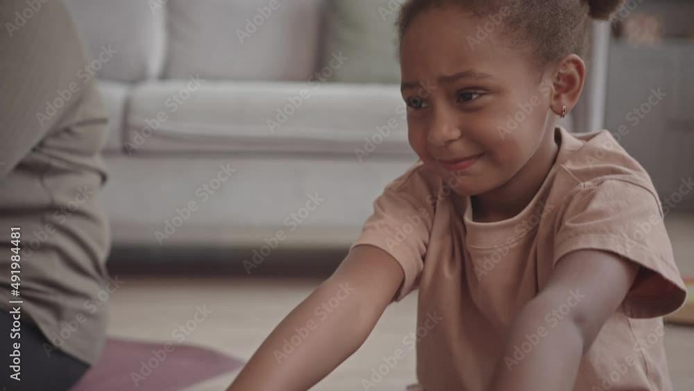 Dolly slowmo of gen A African-American little girl doing stretching exercises on yoga mat at home Dolly slowmo of gen A African-American little girl doing stretching exercises on yoga mat at home