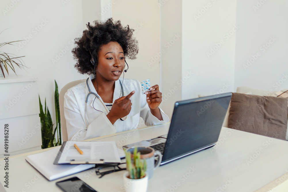 Beautiful female doctor using technology to talk to her patients. Young African-American female doctor provides medicinal help to patient online. People and Healthcare concept. Beautiful female doctor using technology to talk to her patients. Young African-American female doctor provides medicinal help to patient online. People and Healthcare concept.