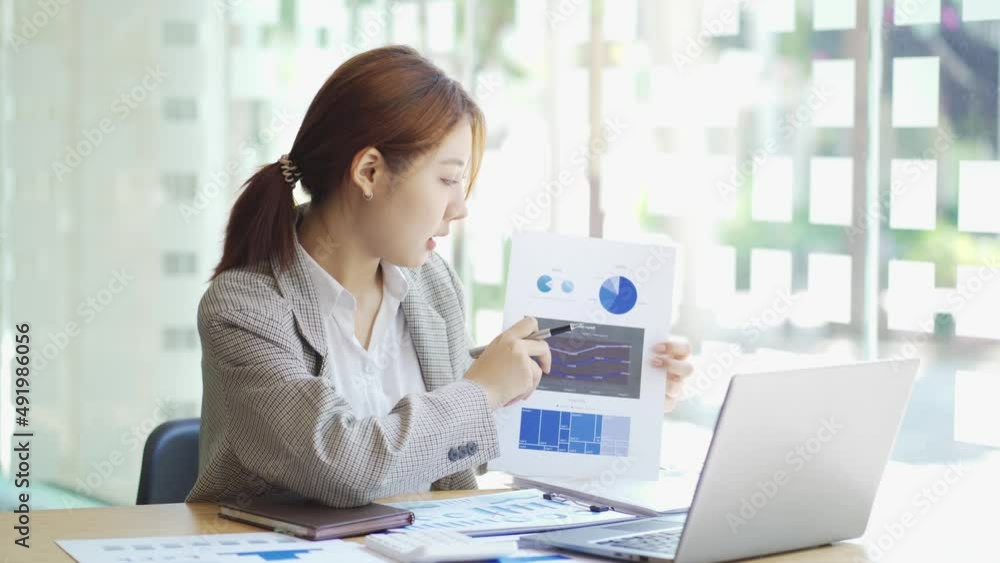 Young Asian businesswoman work at home and virtual video conference meeting with colleagues business people, online working, video call due to social distancing at home office. Young Asian businesswoman work at home and virtual video conference meeting with colleagues business people, online working, video call due to social distancing at home office.