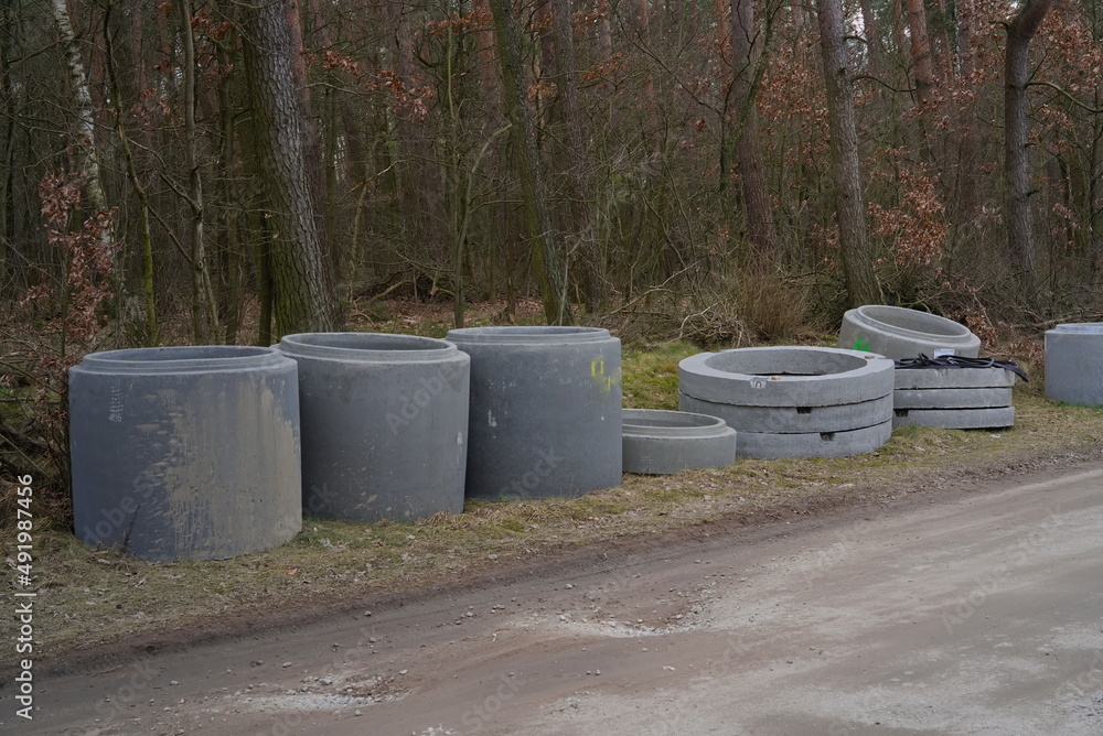 Concrete tube sewers on the road in the forest 