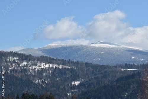 Babia góra, śnieg na drzewach, chmury na niebie.