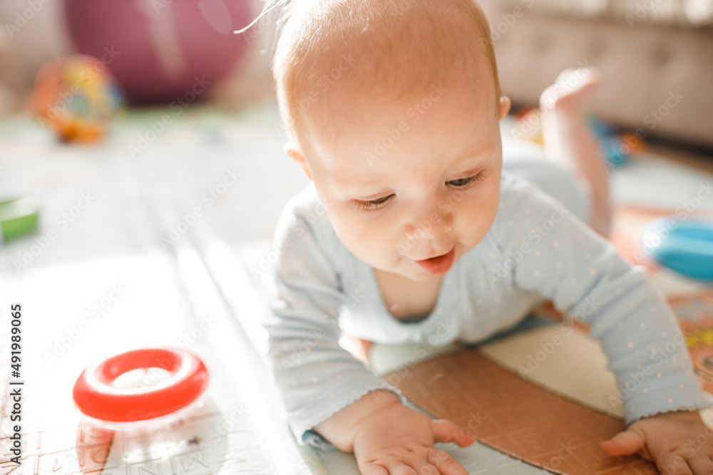 Portrait of wonderful baby girl laying on comfortable bed at home, adorable cute toddler look around with big interest, smiling, childhood and childcare concept Portrait of wonderful baby girl laying on comfortable bed at home, adorable cute toddler look around with big interest, smiling, childhood and childcare concept