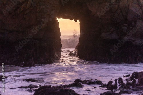 A sunset sky peeping thought the keyhole arch at Pfeiffer Beach, near Big Sur California. © Goldilock Project