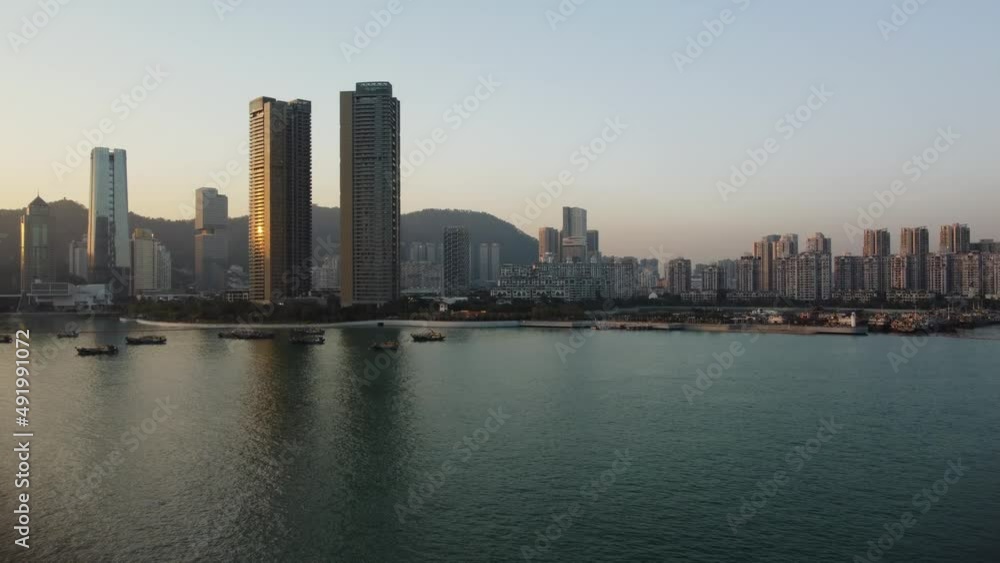 Air view city skyline at sunset. Several boats in the sea. Tall buildings on the horizon. Twilight
Air view city skyline at sunset. Several boats in the sea. Tall buildings on the horizon. Twilight