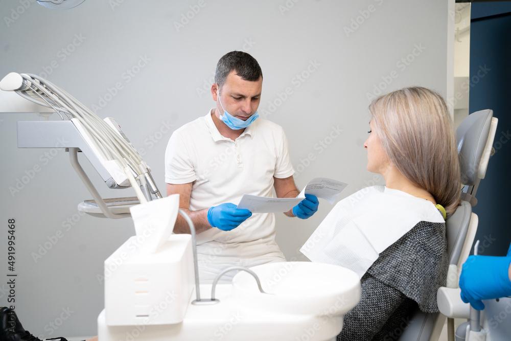 small conversation between a patient and a dentist, preparing for a dental checkup in a dental office. Regular visits to the orthodontist. small conversation between a patient and a dentist, preparing for a dental checkup in a dental office. Regular visits to the orthodontist.