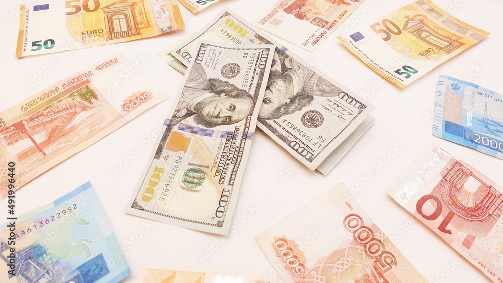 Top view of aa multi-currency. Euro, dollar, ruble banknotes isolated on white background.Cash. The concept of financial literacy and savers. stack of dollar surrounded by euros and rubles Top view of aa multi-currency. Euro, dollar, ruble banknotes isolated on white background.Cash. The concept of financial literacy and savers. stack of dollar surrounded by euros and rubles