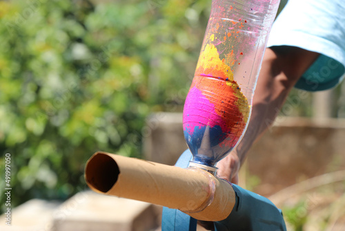 Plastic bottle with many color powders attached to some gadget that blows out the color powder, Holi gadget for gulal throwing