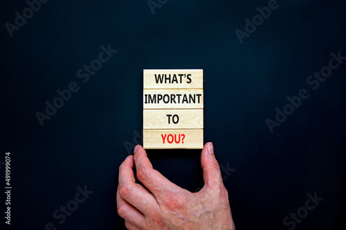 What is important to you symbol. Concept words What is important to you on blocks. Businessman hand. Beautiful black table black background. What is important to you business concept. Copy space.
