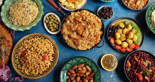 Traditional Halal Middle Eastern cuisine. Falafel, samosa, chickpeas, beans, pita bread, pilaf, tajine, couscous, dates, olives. Eid Al Fitr holiday celebration