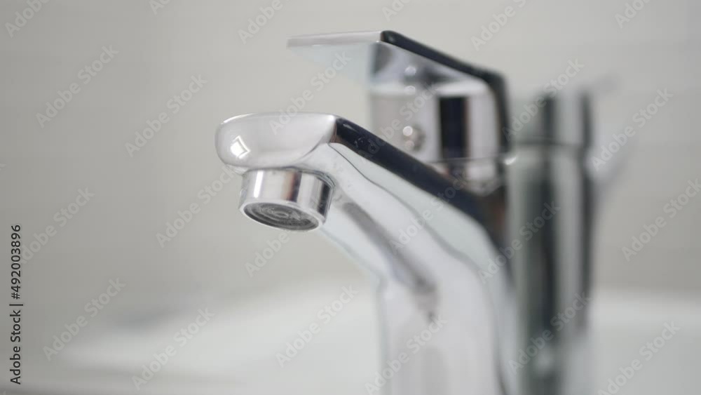 Medical Person Wearing Protective Gloves in Hands Closing the Sink Tap from the Bathroom. Medical Person Wearing Protective Gloves in Hands Closing the Sink Tap from the Bathroom.