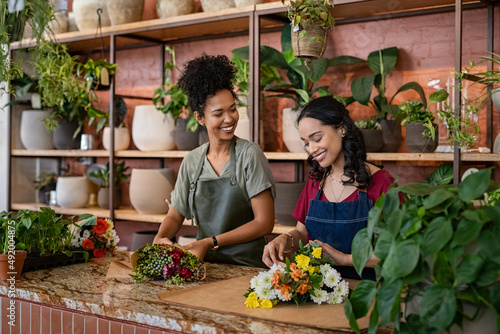 Two multiethnic women working in florist shop together photo