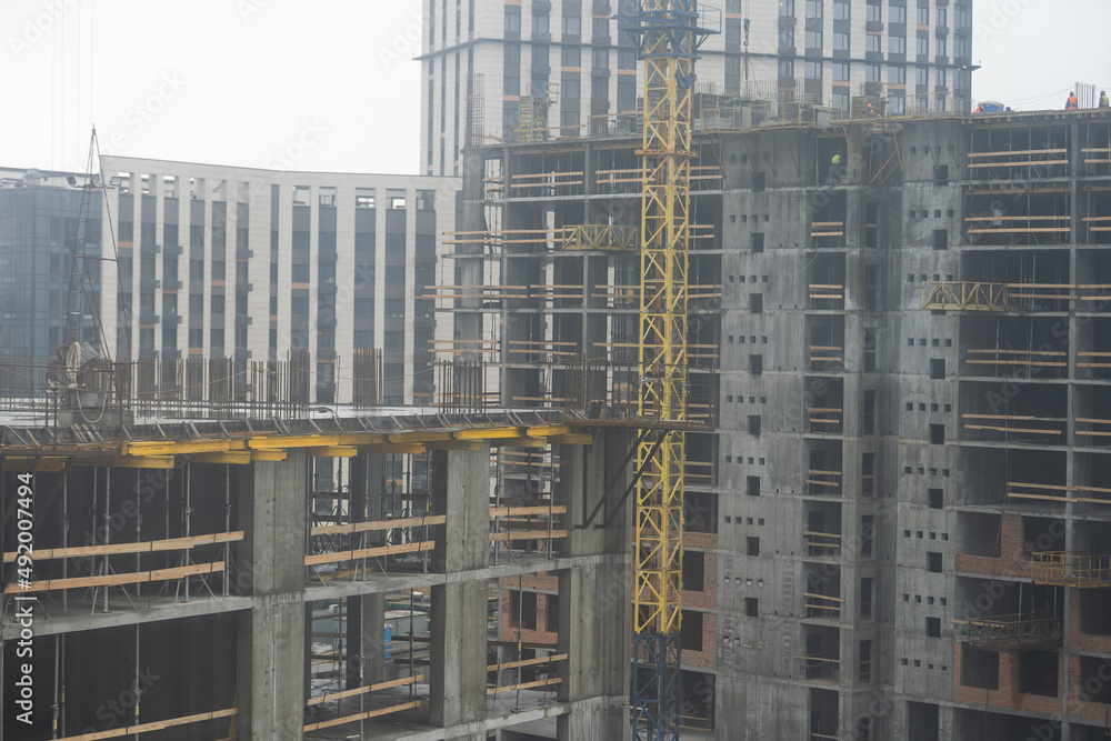 Large construction site including several cranes working on a building complex,