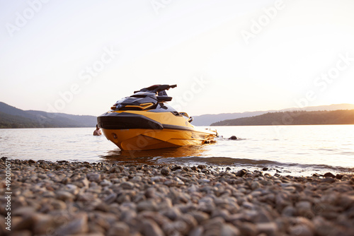 Modern water scooter at river rocky beach. Summer holidays. Sunset light. photo