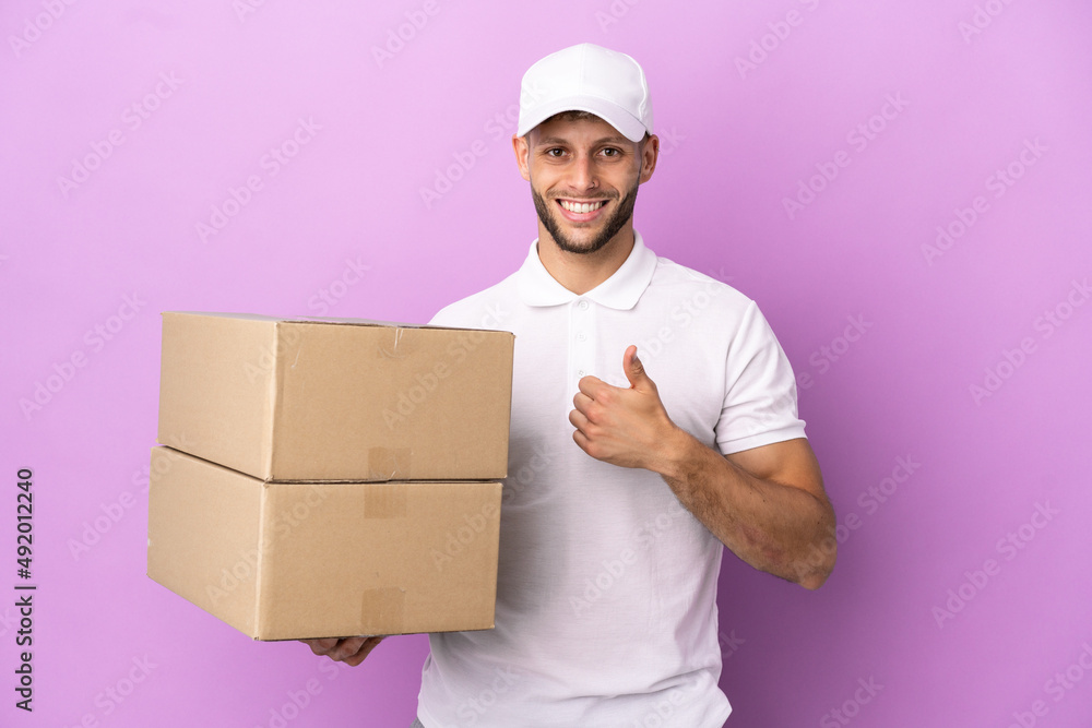 Delivery caucasian man isolated on purple background giving a thumbs up gesture Delivery caucasian man isolated on purple background giving a thumbs up gesture