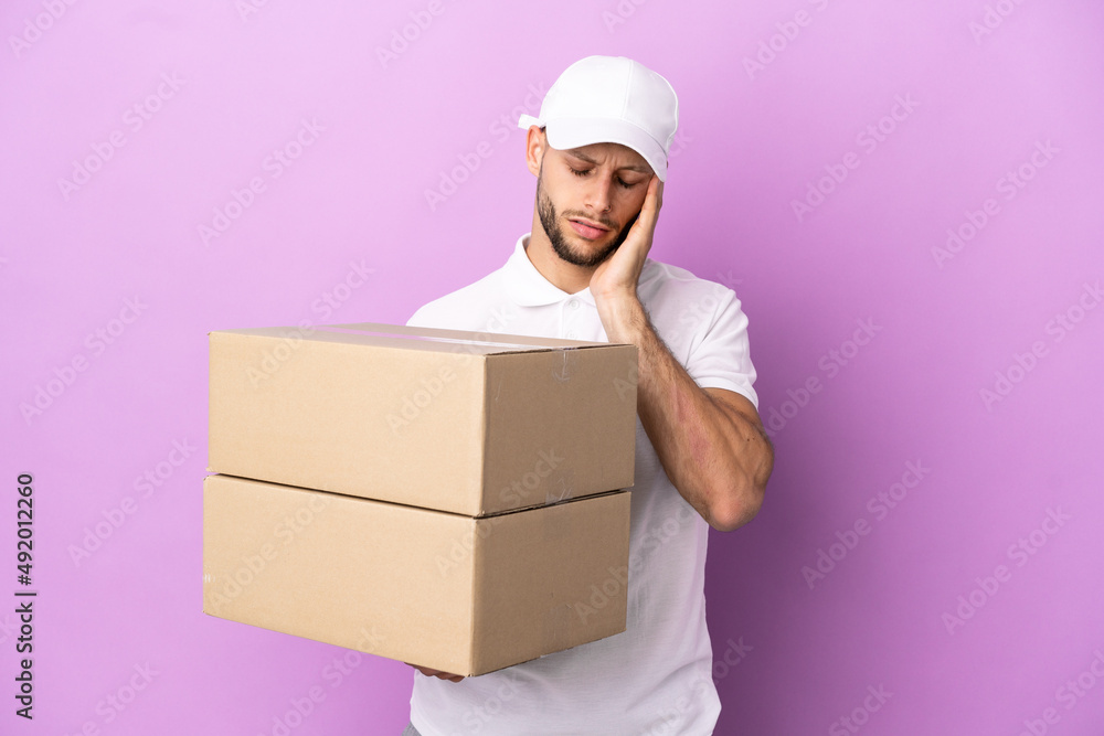 Delivery caucasian man isolated on purple background with headache Delivery caucasian man isolated on purple background with headache