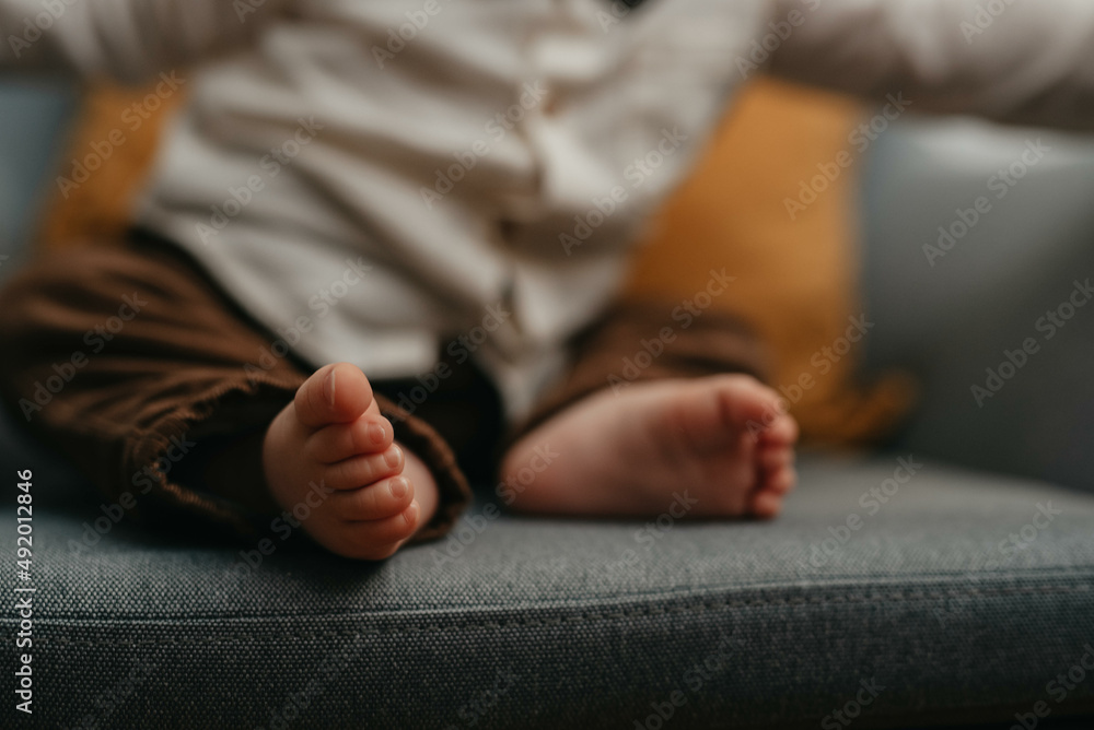 Feet of a baby in the hands of parents. Happy Family concept. Mum and Dad hug their baby's legs. Feet of a baby in the hands of parents. Happy Family concept. Mum and Dad hug their baby's legs.
