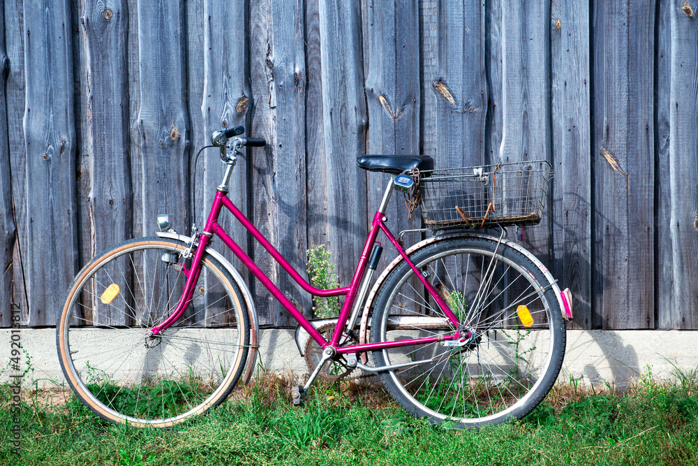 Old bicycle on a background of a wooden wall.