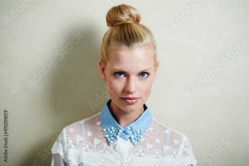 Casual yet stylish. A young woman with her hair in a bun posing in casual wear. photo