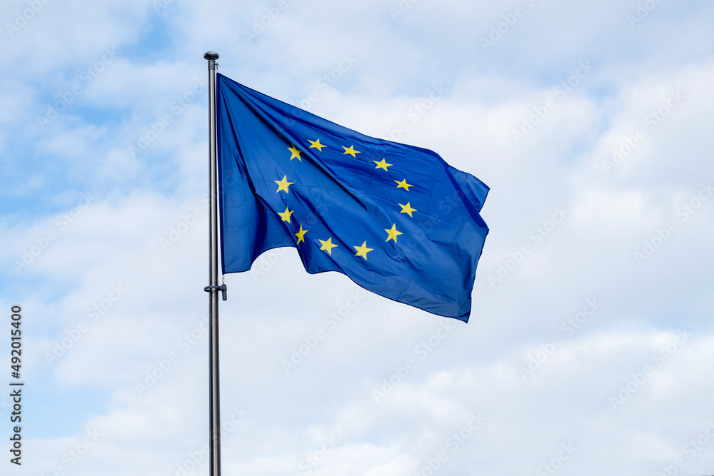 Panoramic view of a waving EU flag or European Union flag against blue sky.