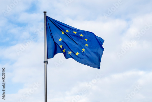 Panoramic view of a waving EU flag or European Union flag against blue sky.