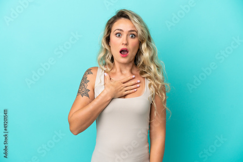 Young Brazilian woman isolated on blue background surprised and shocked while looking right