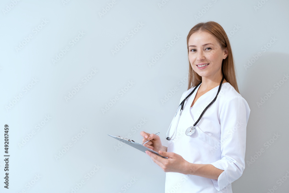 Smiling general practitioner with stethoscope holding folder with documents Smiling general practitioner with stethoscope holding folder with documents