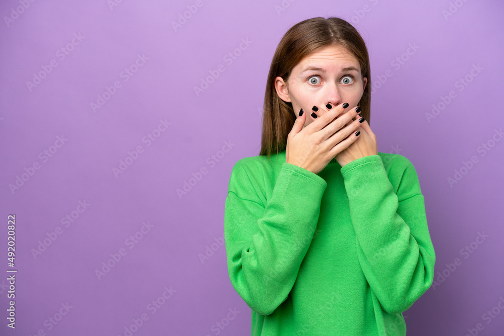 Young English woman isolated on purple background covering mouth with hands Young English woman isolated on purple background covering mouth with hands