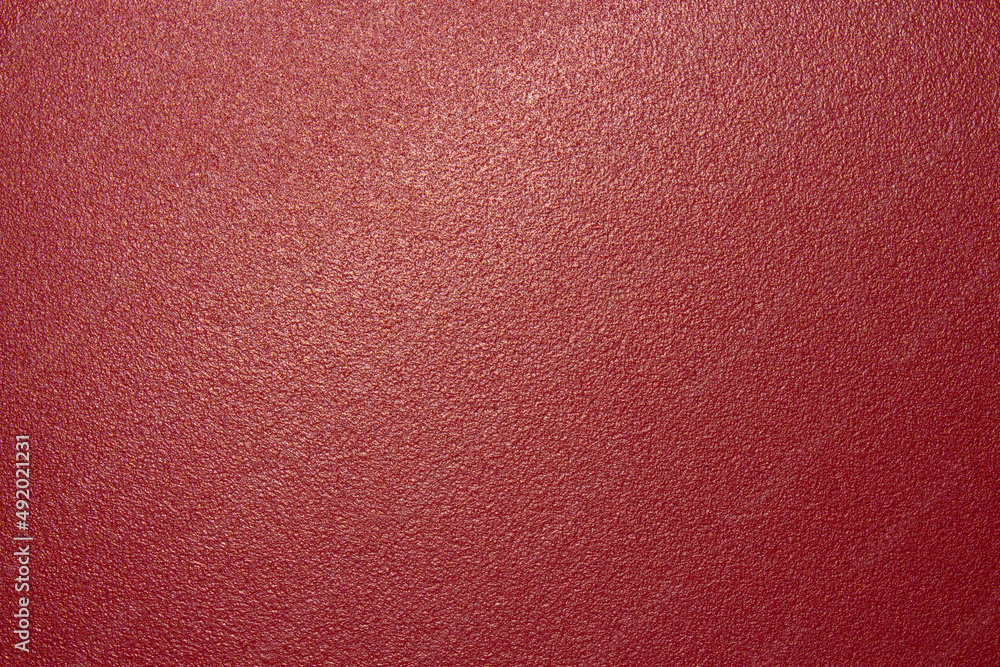 The texture of the red matte plastic.Red matte background.The background is red rough plastic. The texture of the red matte plastic.Red matte background.The background is red rough plastic.