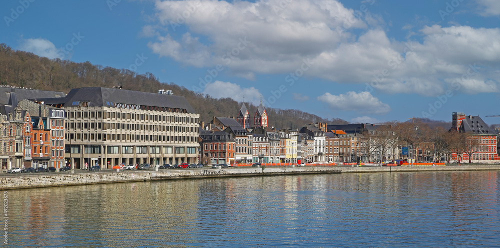 Liege, Belgium - March 5. 2022: View over river maas on historical waterfront houses against blue winter sky