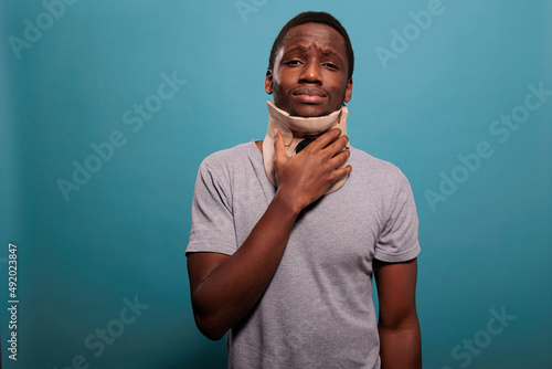 Foto Adult in pain wearing cervical collar to recover from fracture accident, feeling upset about physical pain