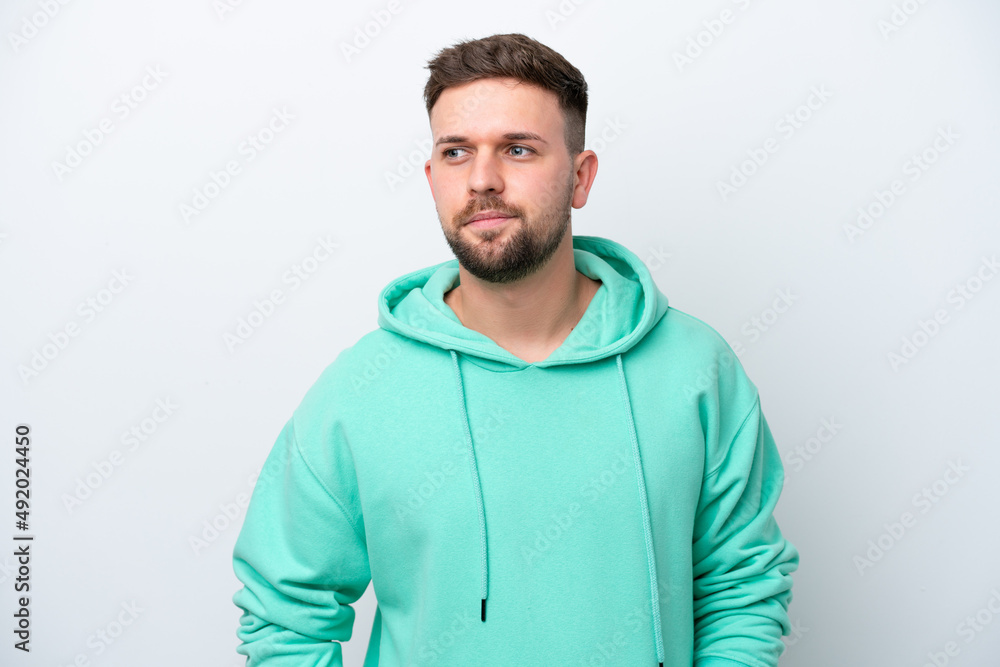 Young caucasian man isolated on white background having doubts while looking side Young caucasian man isolated on white background having doubts while looking side