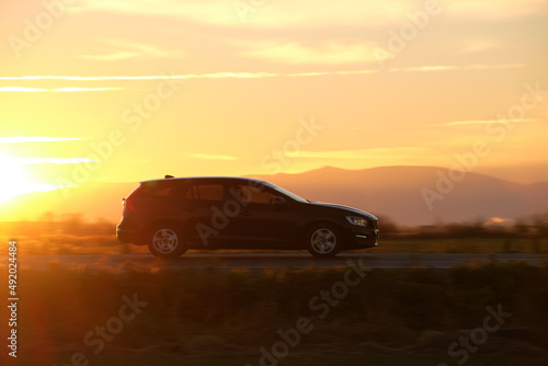 Car driving fast on intercity road at sunset. Highway traffic in evening © bilanol