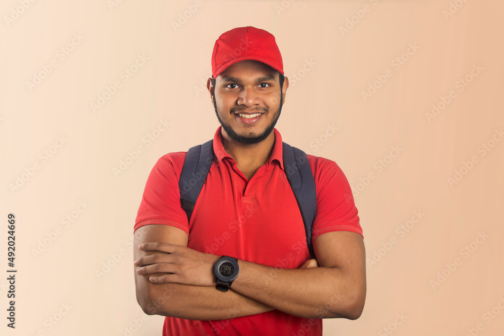 Portrait of a confident young delivery man standing with arms folded isolated over Color background Portrait of a confident young delivery man standing with arms folded isolated over Color background