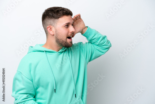 Young caucasian man isolated on white background with surprise expression while looking side © luismolinero