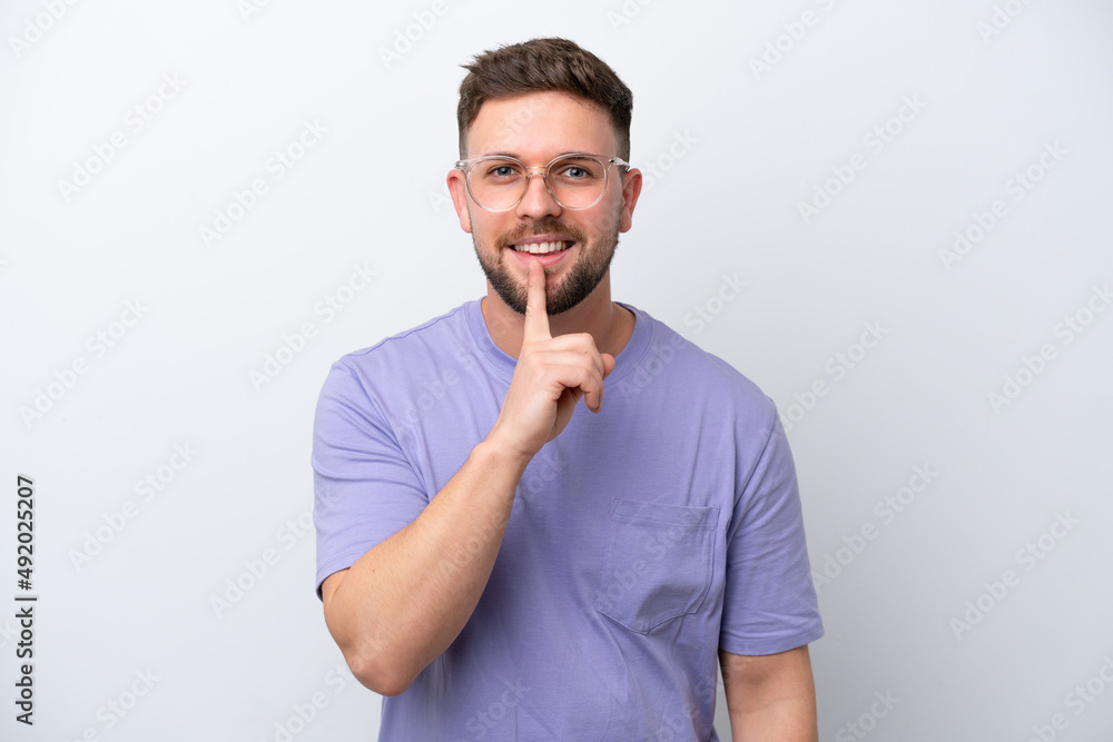 Young caucasian man isolated on white background showing a sign of silence gesture putting finger in mouth Young caucasian man isolated on white background showing a sign of silence gesture putting finger in mouth