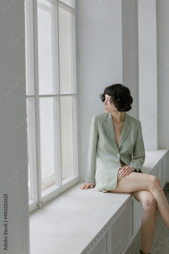 Stylish and cute girl in fashionable clothes in a minimalist interior Stylish and cute girl in fashionable clothes in a minimalist interior