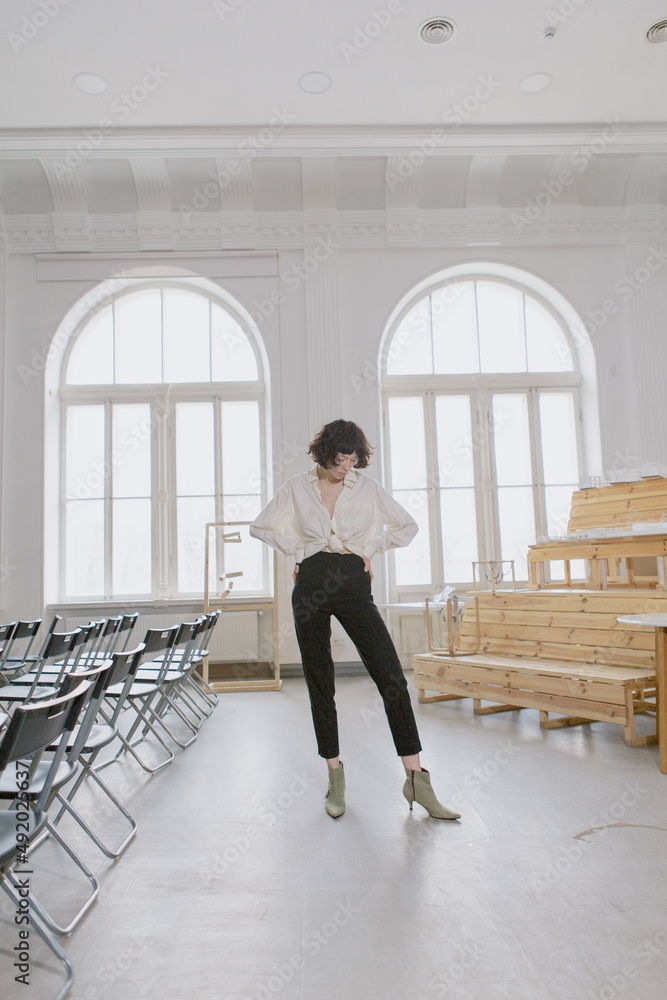 Fototapeta premium Stylish and cute girl in fashionable clothes in a minimalist interior