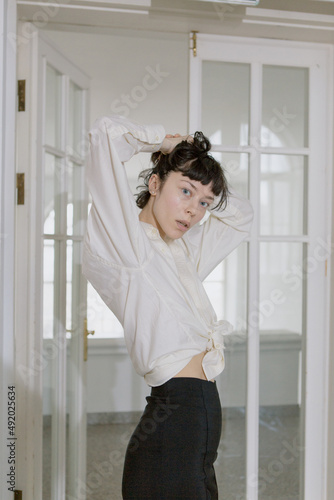 Stylish and cute girl in fashionable clothes in a minimalist interior