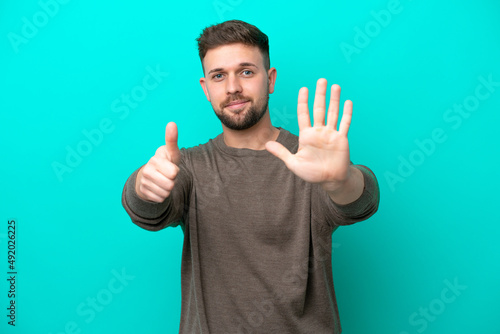 Young caucasian man isolated on blue background counting six with fingers © luismolinero