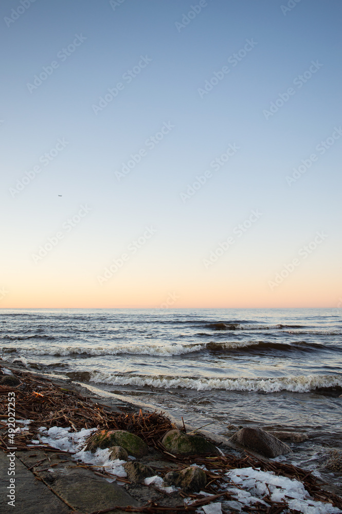 Seascape at sunset. Minimalistic cold sea view at sunset. Clear sky, horizon over water