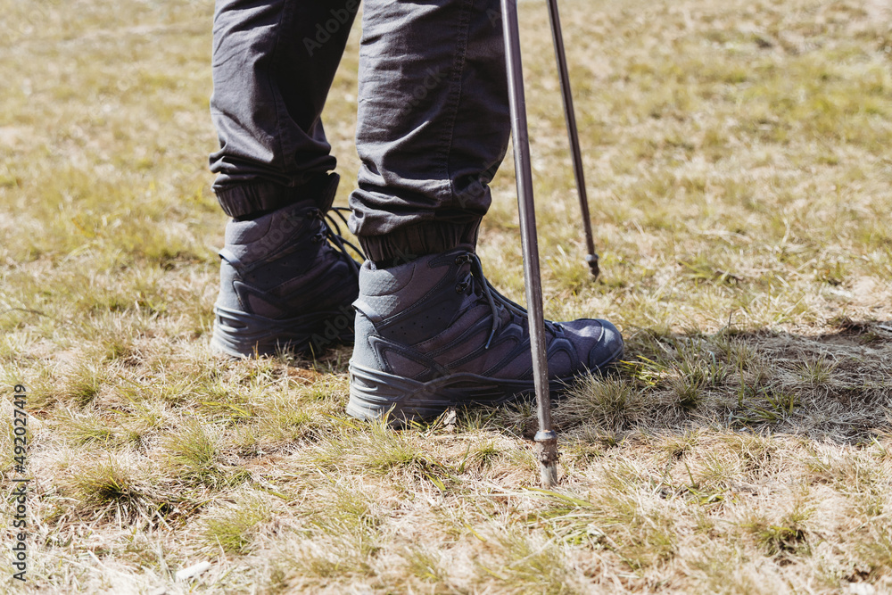 Hiker man with trekking sticks climbing in mountains Hiker man with trekking sticks climbing in mountains