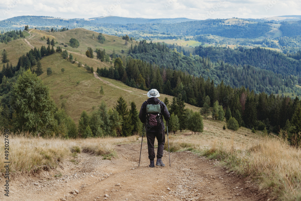 Hiker man with backpack and trekking sticks Hiker man with backpack and trekking sticks