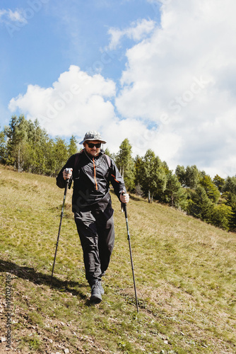 Hiker man with backpack and trekking sticks