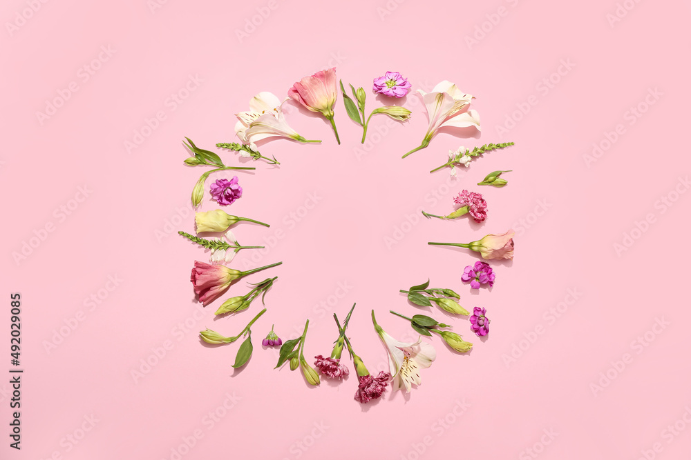 Fototapeta premium Frame made of blooming flowers on color background