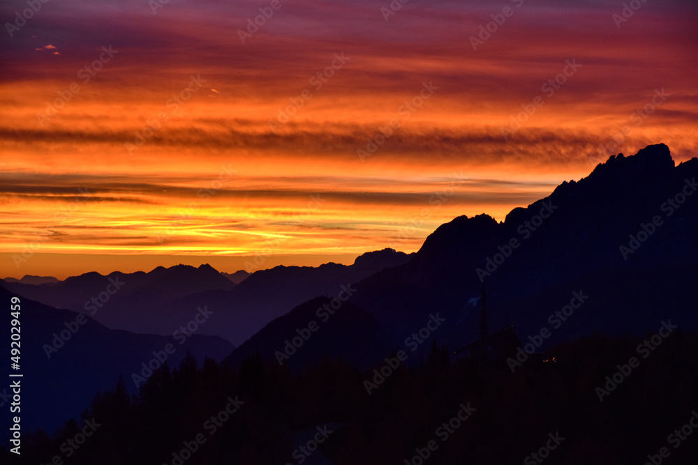 Fototapeta premium Sonnenaufgang, Morgendämmerung, Morgenrot, Himmel, Berge, Silhouette, Nacht, Tag, Dämmerung, blaue Stunde, Sonne, Sonnenstrahlen, leuchten, anleuchten, erstrahlen, Wolken, Wolkenschleier, Rot, Orange,