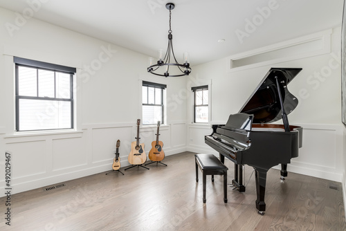 Styled Interior of Music Room. Empty room with grand piano, guitars and ukulele. Private music lesson room.