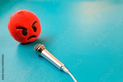 angry face in front of microphone on green background